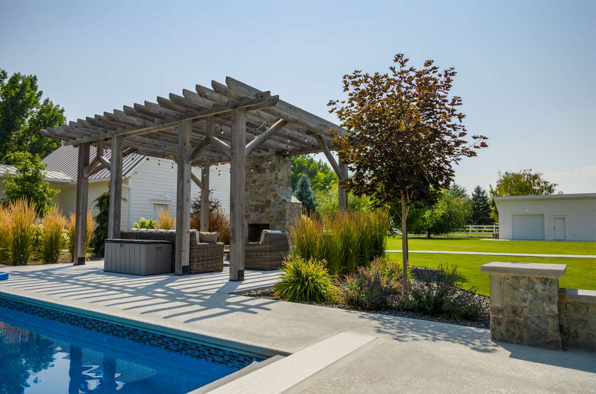 pool pergola fireplace seating patio garage plants grasses trees lawn