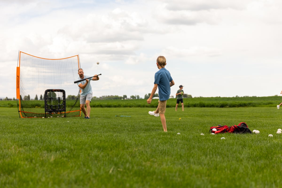 family play baseball on healthy green grass