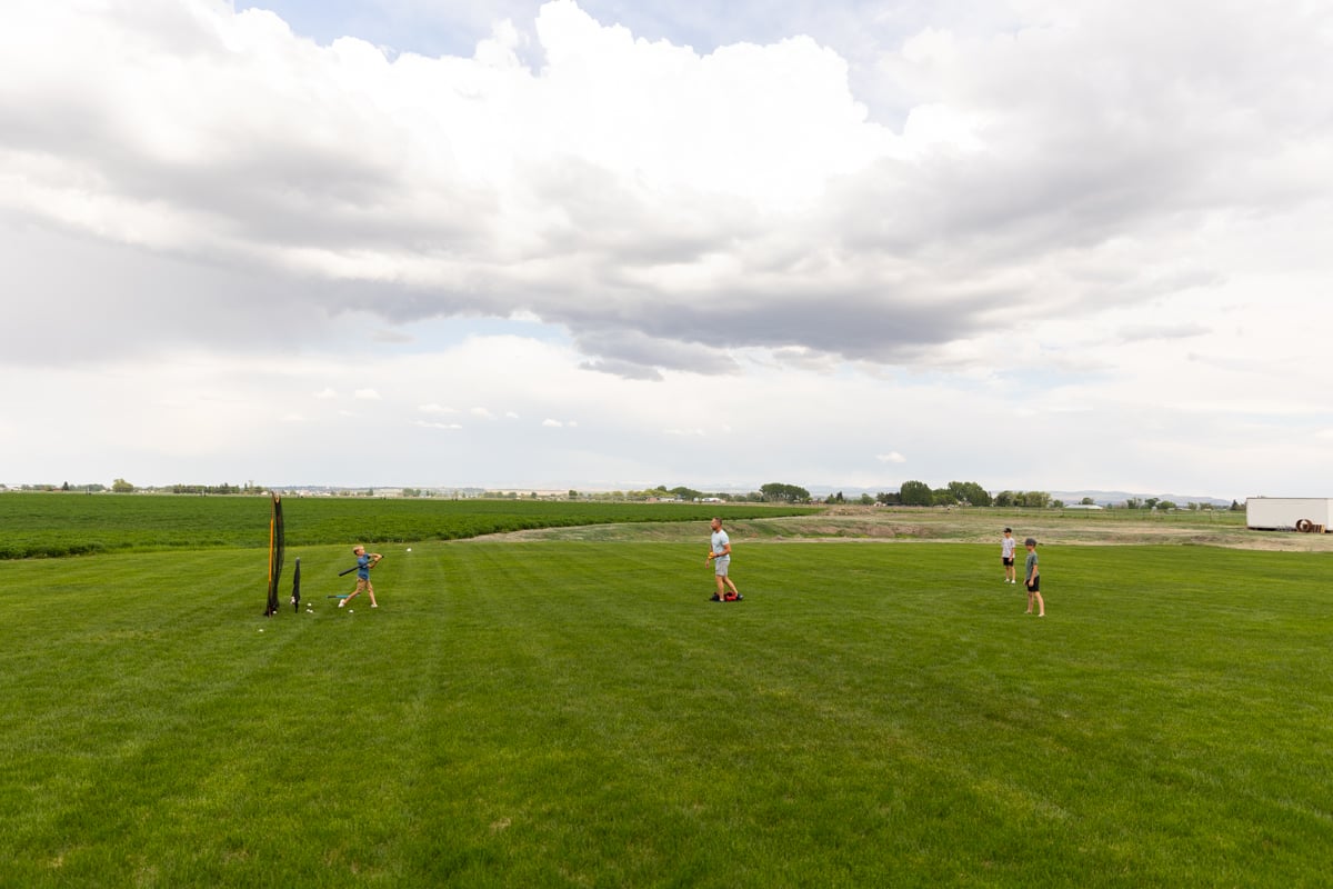 family playing baseball in grass