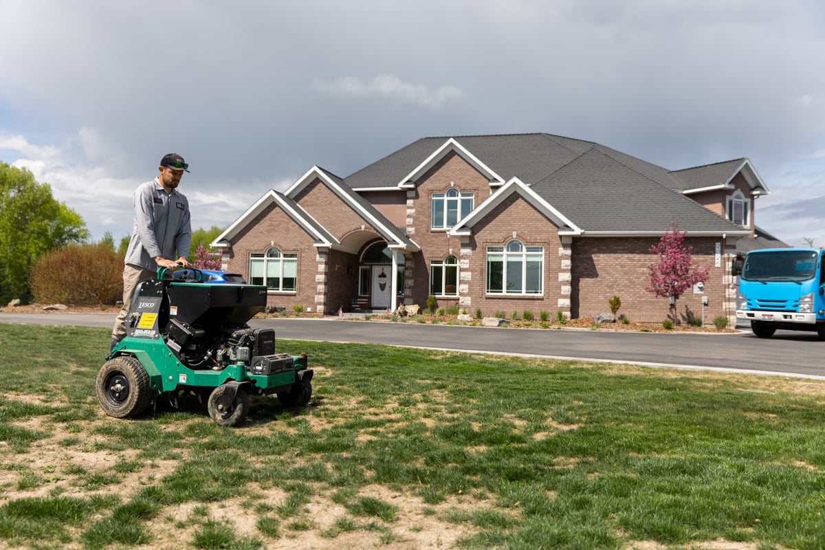 lawn care expert aerates patchy lawn