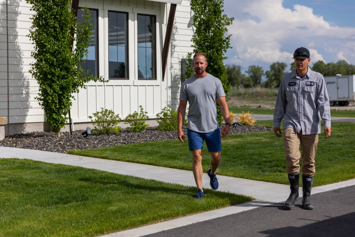 homeowner and lawn care technician inspect property