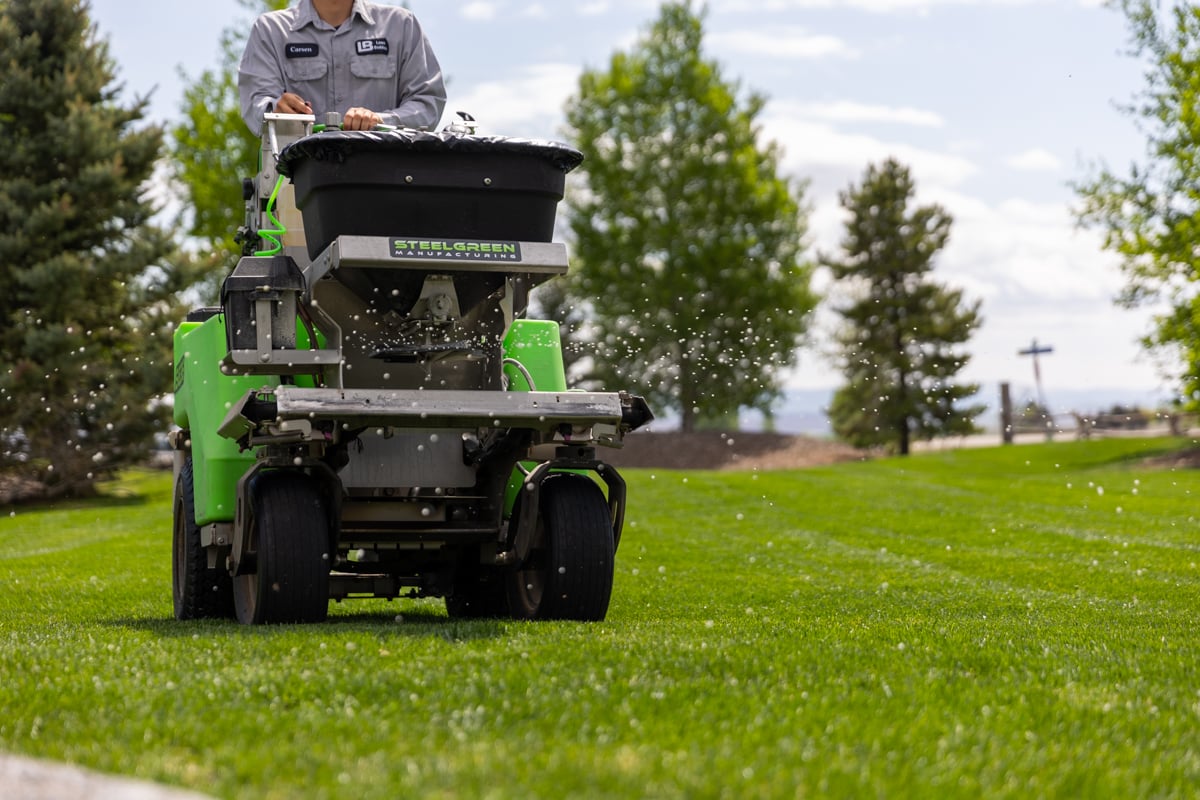 lawn care company fertilizes grass