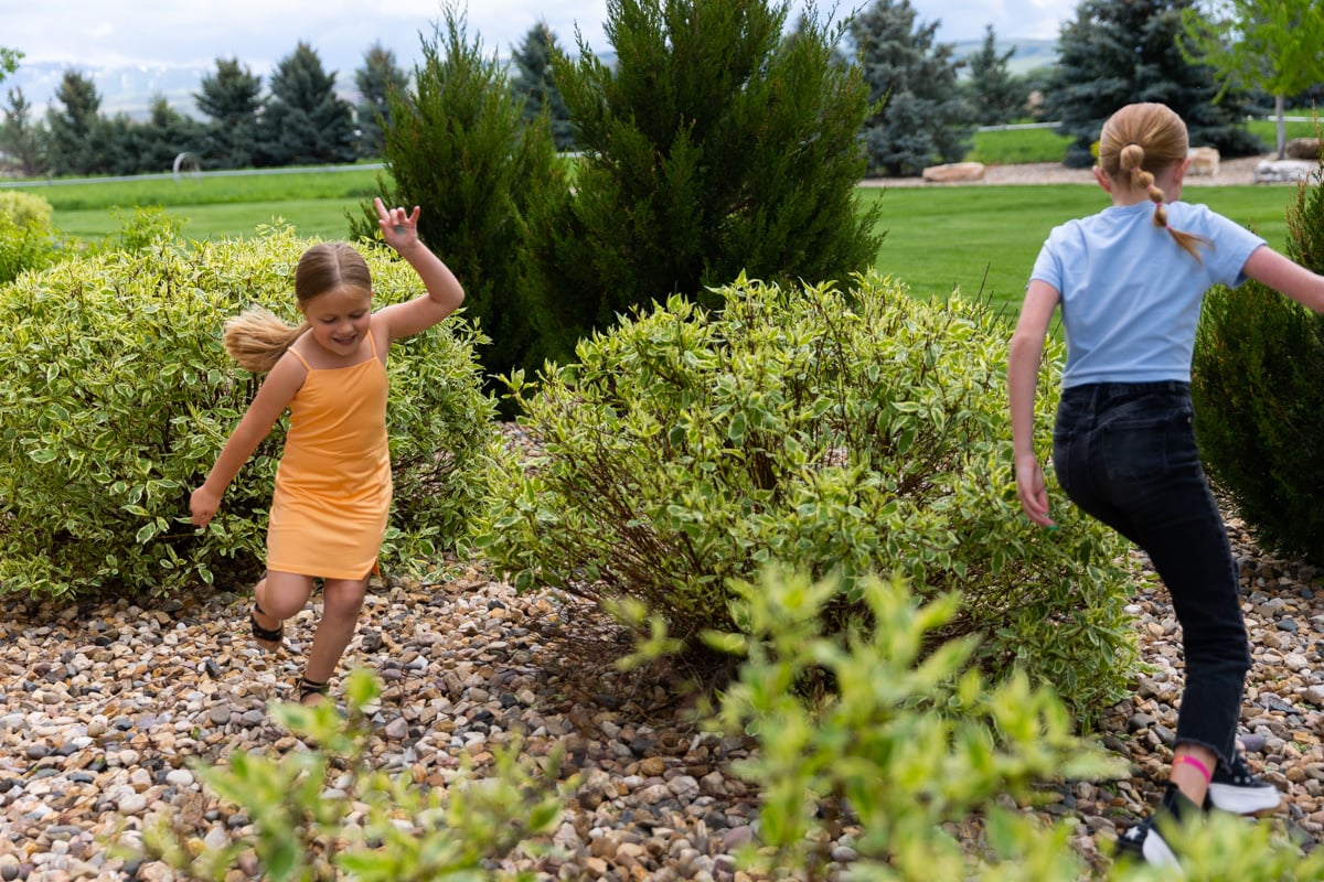 Happy Kids Playing in River Rock Bed Shrubs 4