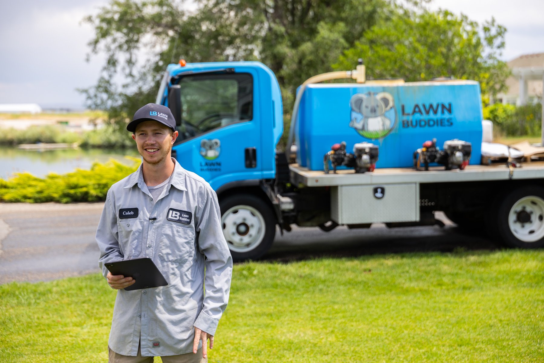 lawn care technician holding tablet inspection spray truck yard equipment